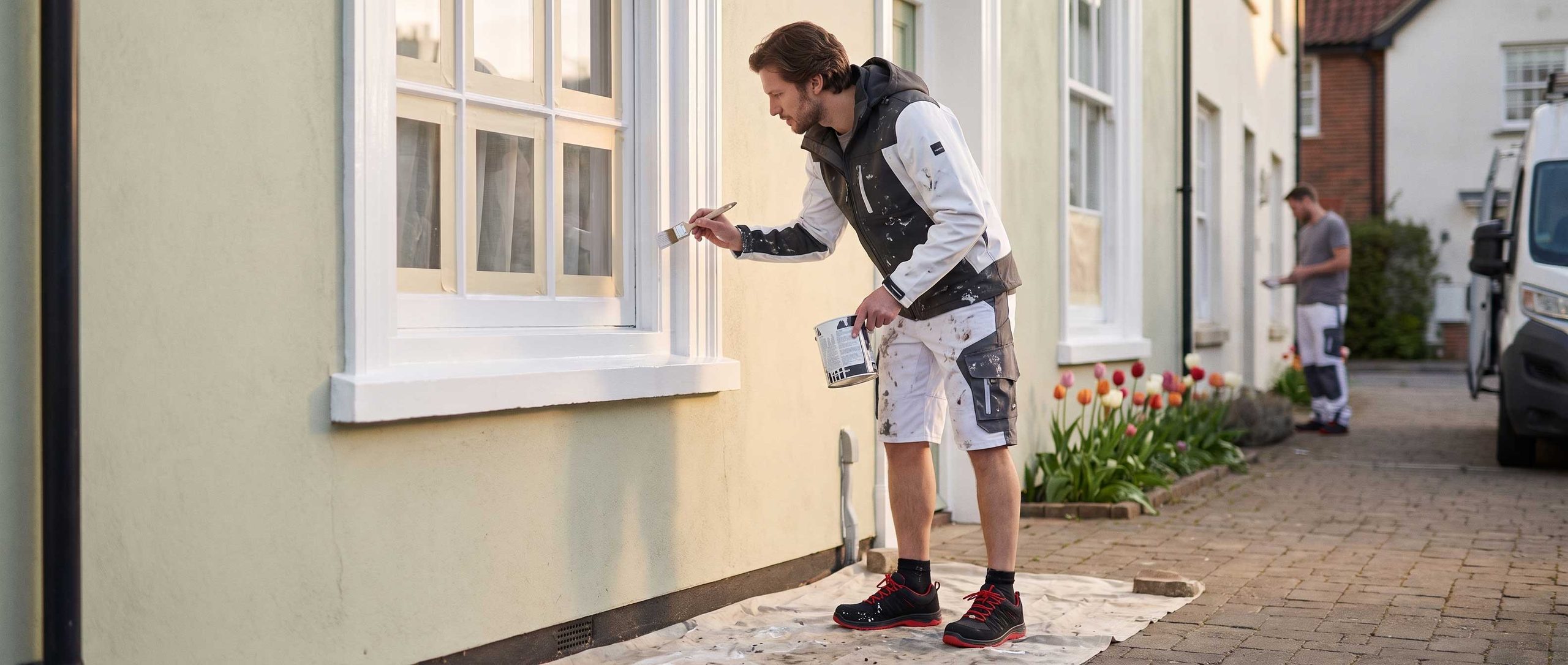 Maler beim Lackieren eines Fensterrahmens